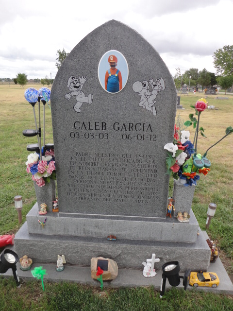 A headstone surrounded by toys
