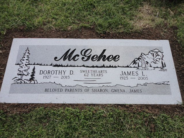 A headstone depicting a lake, a pine tree, and a mountain