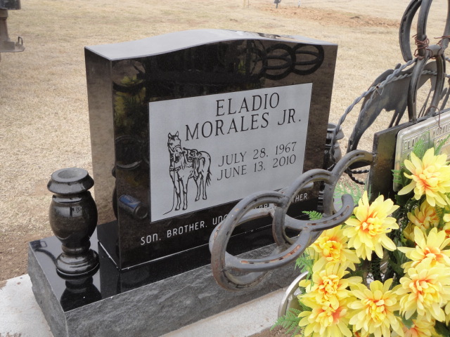 A black headstone for Eladio Morales Jr. with a horse design