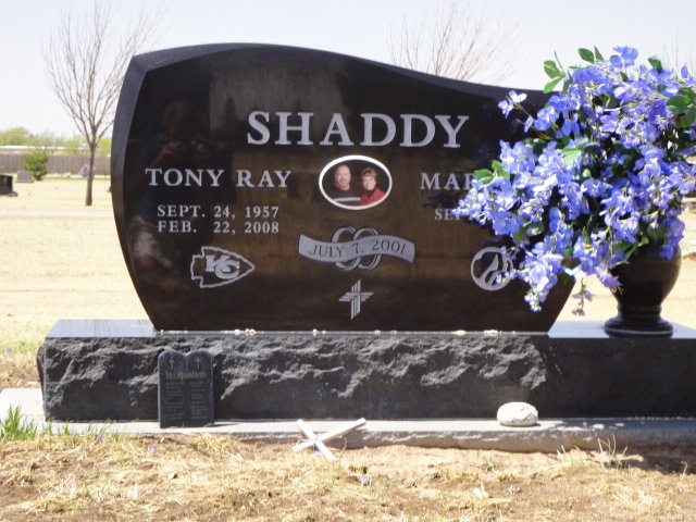 A monument for the Shaddy couple with blue flowers