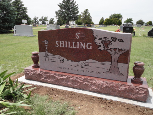 A monument for Shilling with a design featuring a tree, a windmill, and animals